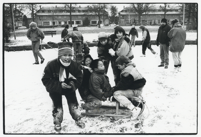 109277 Afbeelding van spelende kinderen in het besneeuwde Park Oog in Al te Utrecht. Op de achtergrond de huizen aan de ...